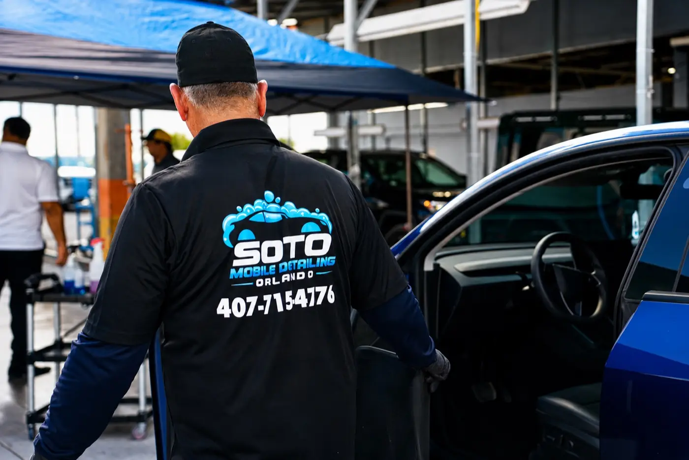 Mobile detailing company in Orlando, FL Soto detailer working under the mobile canopy in an Orlando parking lot