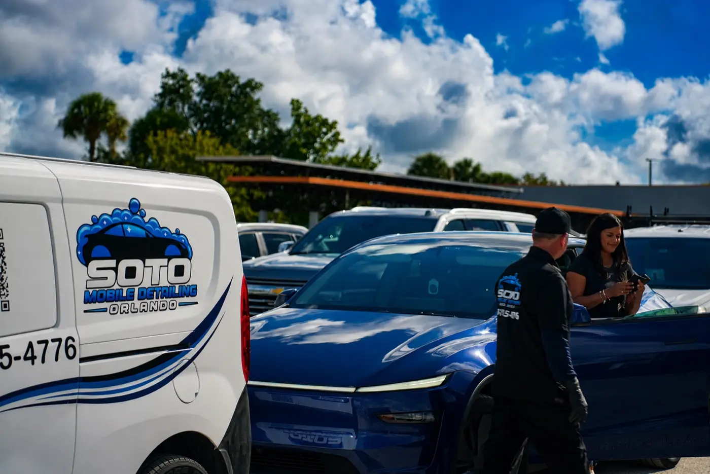 Mobile detailing company in Orlando, FL Customer and Soto detailer beside the freshly detailed blue car with the Soto van behind