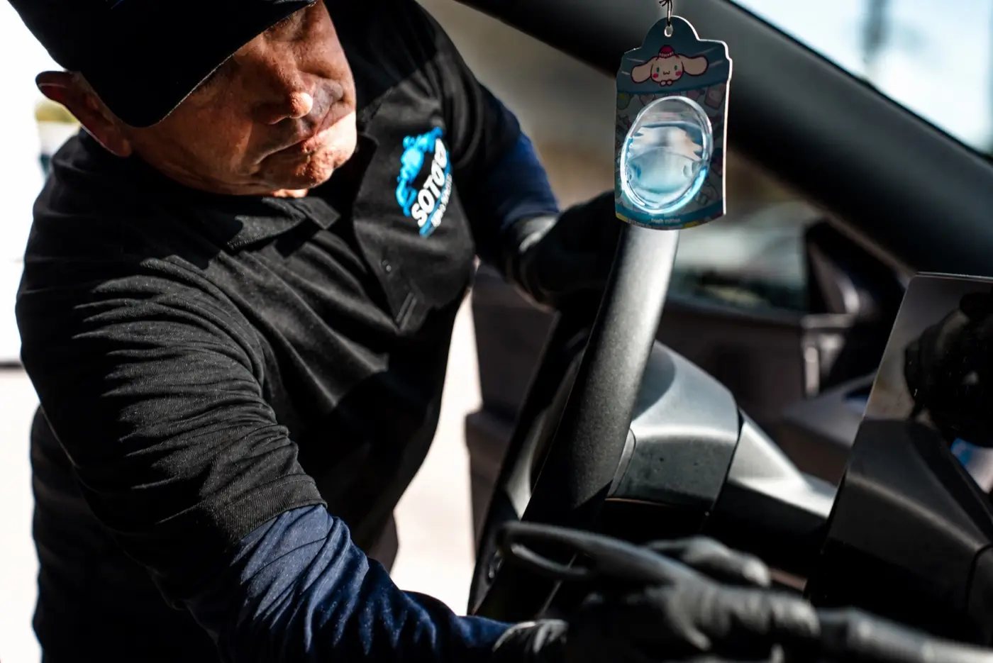 Mobile detailing company in Orlando, FL Soto detailer wiping the mirror area inside a customer car