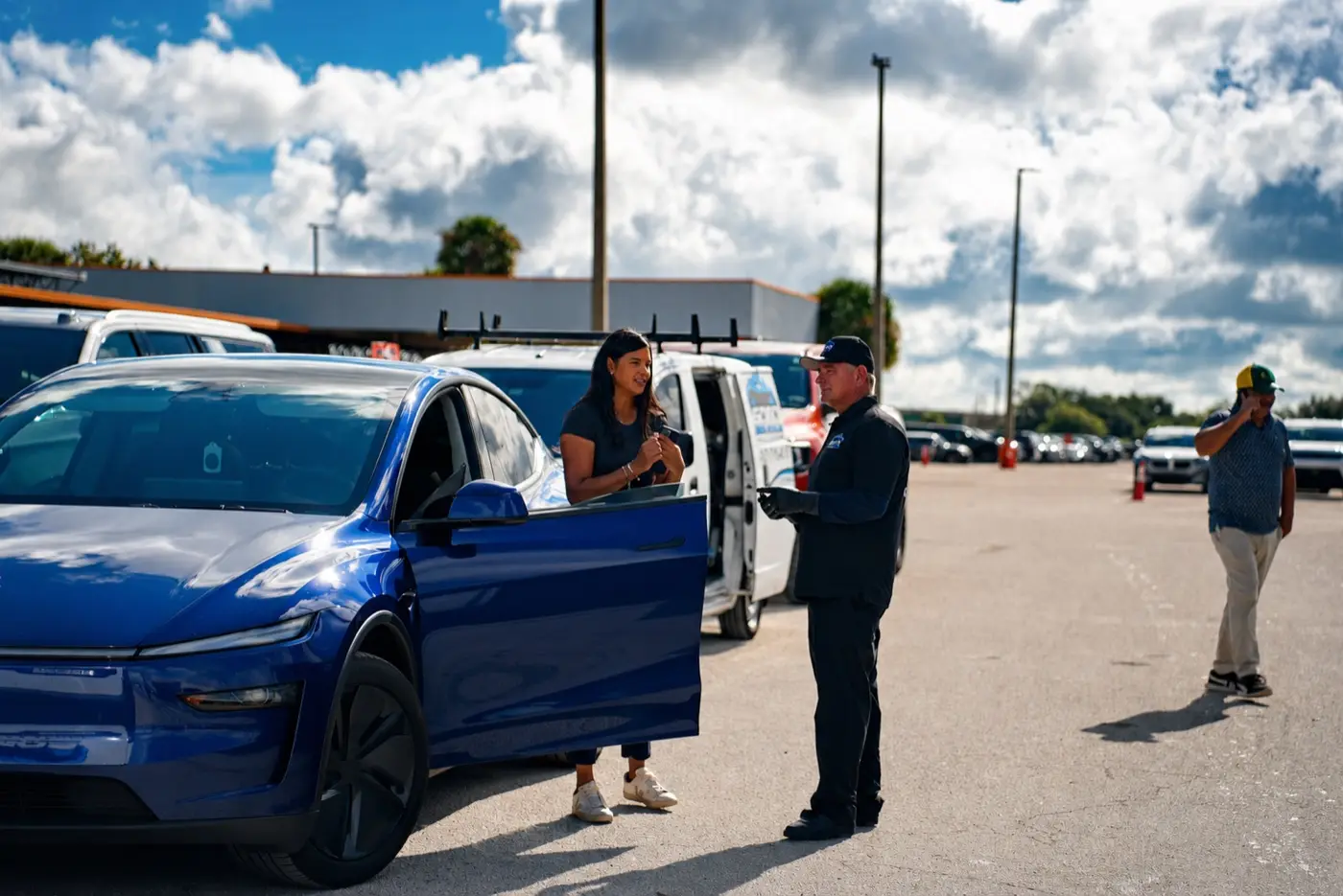 Mobile detailing company in Orlando, FL Soto van, blue car, customer and detailer on location in an Orlando lot